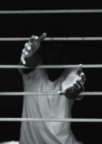 person grayscale photography of man in front of window finger