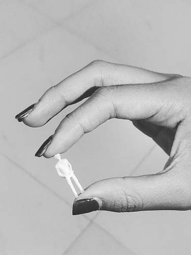 black-and-white grayscale photography of person holding tiny action figure grey
