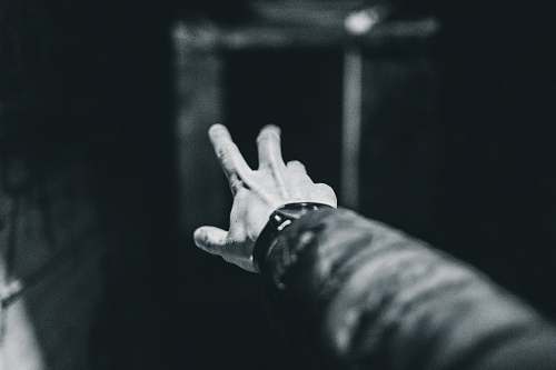 finger grayscale photography of person showing left hand grey