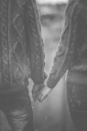 black-and-white man and woman holding each others hands grey