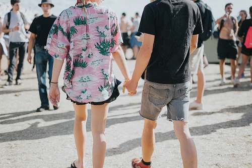 person man and woman holding hands at middle of street apparel