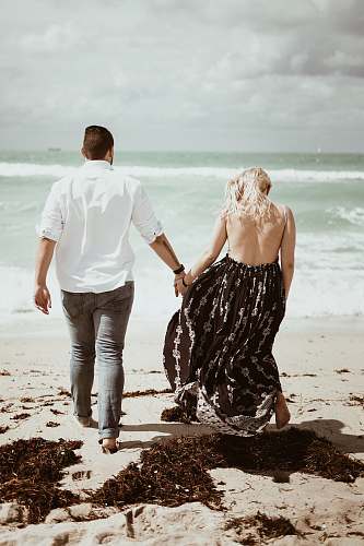 person man and woman on white sand apparel