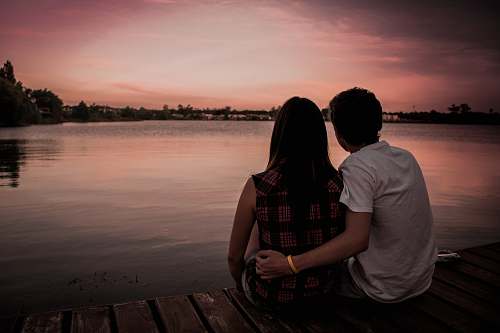 love man and woman sitting on dock couple