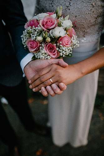 person man and woman standing while holding hands wedding