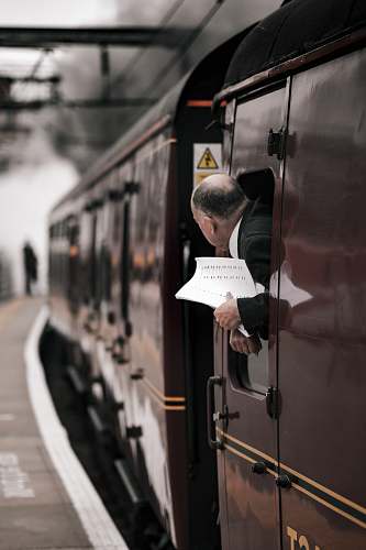 person man on brown train looking outside people
