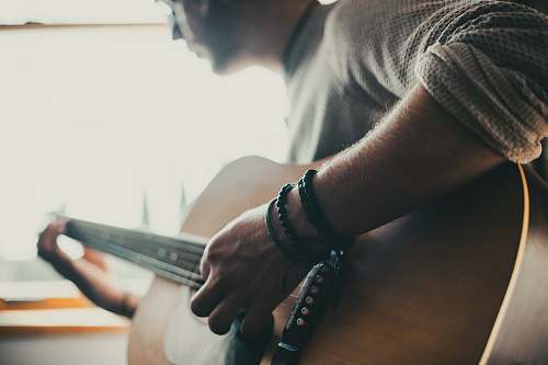 person man playing guitar inside room people