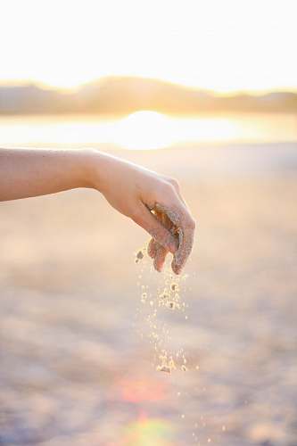 hand person dropping grains of sand holding hands