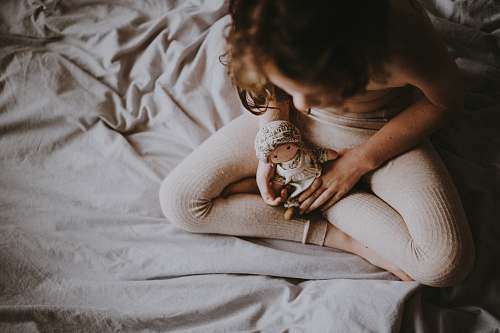 person person holding doll on white textile people
