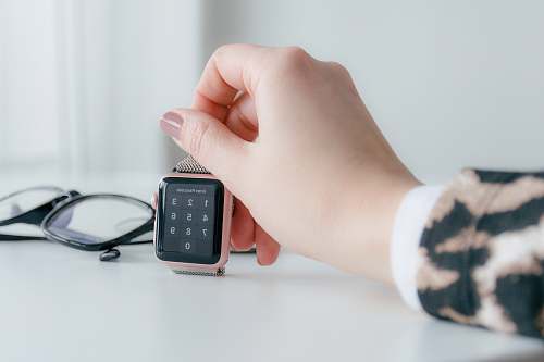 person person holding gold-colored smartwatch mobile phone