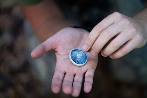person person holding round blue and white ornament finger