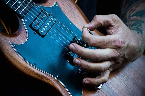 music person plucking electric guitar with guitar pick guitar