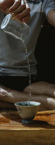 person person pouring water into white ceramic mug hand