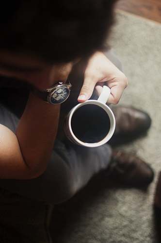person person sitting on couch holding coffee mug coffee