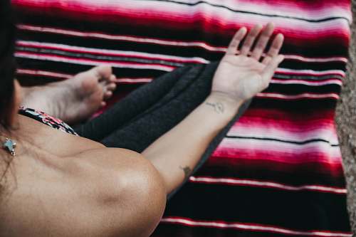 person person sitting on red and black striped mat arm