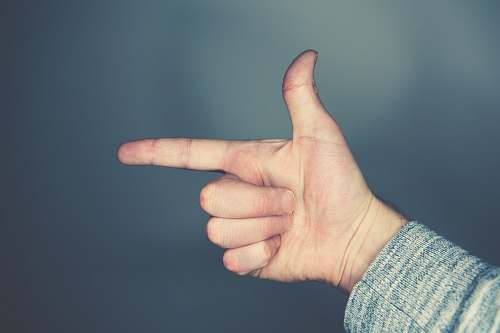 hand person's left hand doing gun sign finger