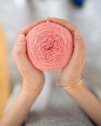 person pink ball of yarn finger