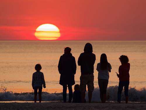 person silhouette photography of people facing ocean during golden hour sunset