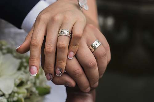 person silver-colored wedding rings finger