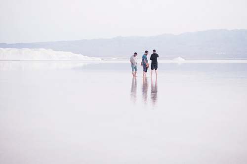 person three men standing on shore standing