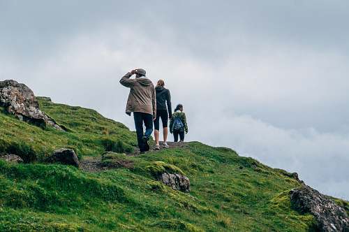 person three person walking on green cliff nature