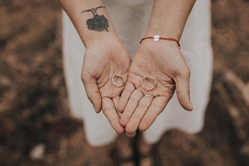person two gold wedding rings on palm skin