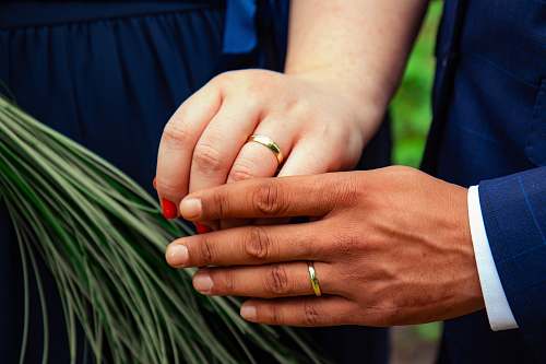 person two person with gold wedding bands in hands finger