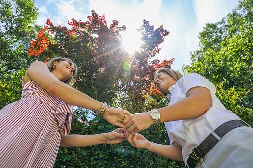 person two woman standing holding hands nature