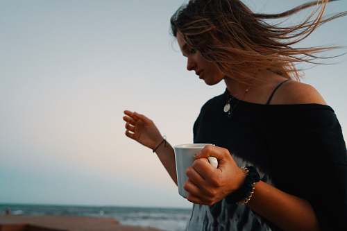 person woman holding white mug finger