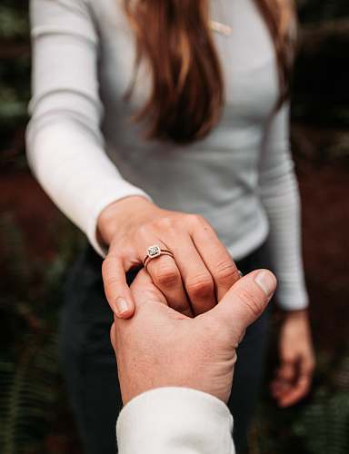 person woman wearing ring holding hand of man hand