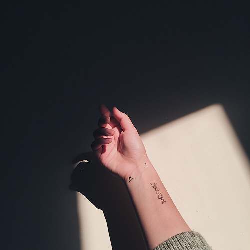 person woman with black arm tattoo finger