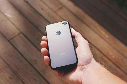 phone person holding jet black iPhone 7 cellphone
