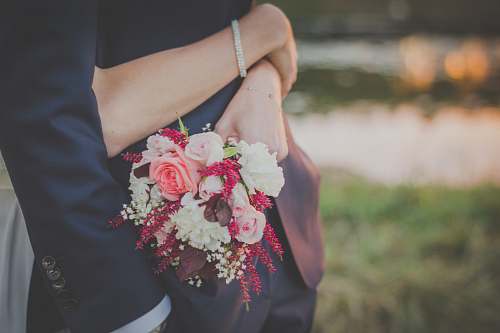 wedding woman holding flower bouquet while hugging man rose