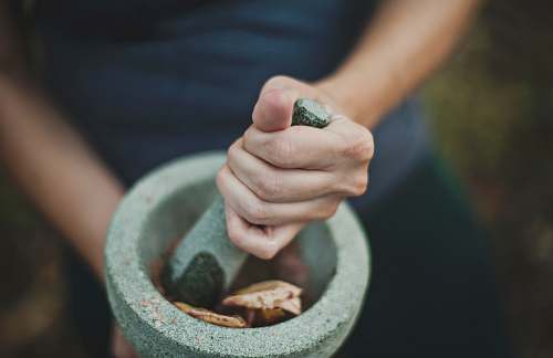 pestal person grinding on mortar and pestle grind