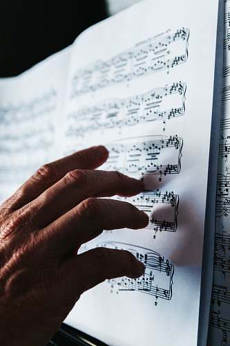 paper person reading musical note sheet