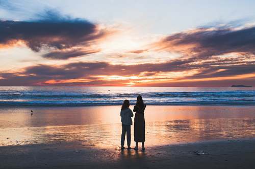 person woman and girl standing on seashore human