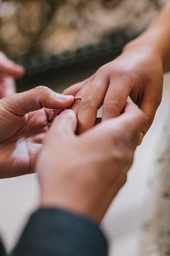 human selective focus photography man attempting to put ring in woman's ring finger person