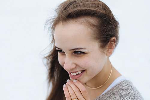 human woman holding her chin while smiling person