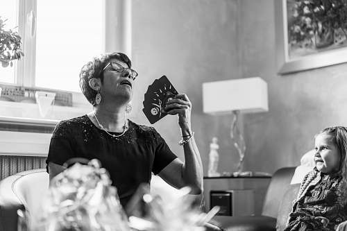 human woman in black t-shirt holding playing cards black-and-white