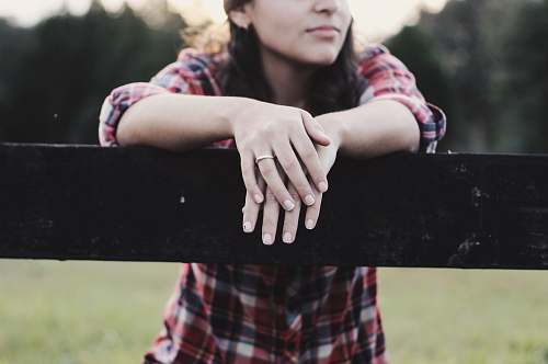 human woman placed her two hands on wooden fence during daytime person