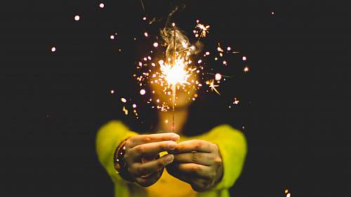 woman woman wearing green shirt holding sparkler spark