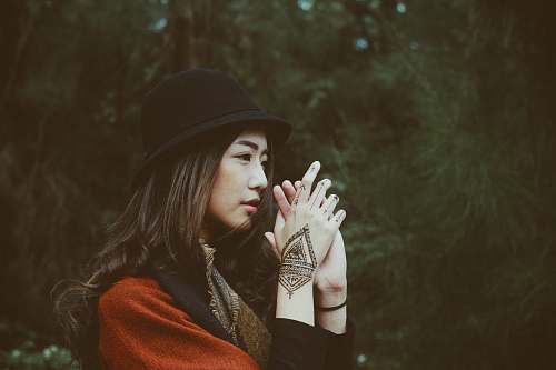human woman wearing red top and black hand clasping her hands woman