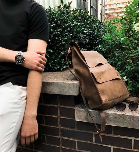 human bag on surface near sunglasses with plants on back people