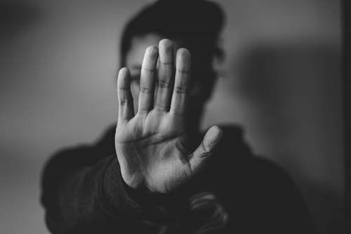 human close-up photography of person lifting hands black-and-white