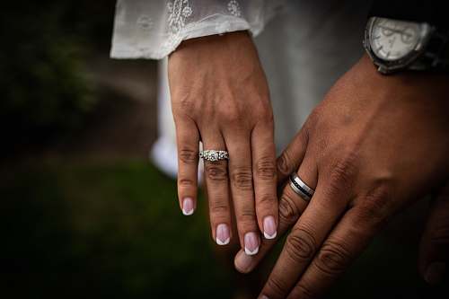 human couple wearing wedding rings wristwatch