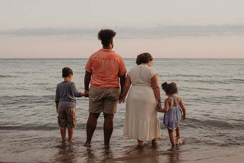 human four people standing on seashore apparel