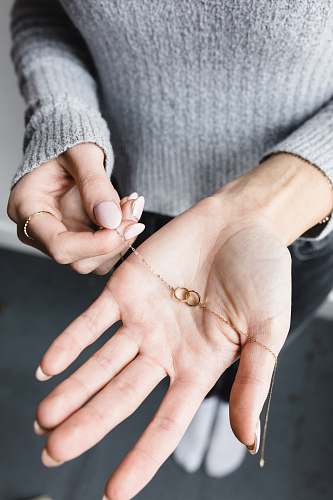 human gold-colored necklace finger