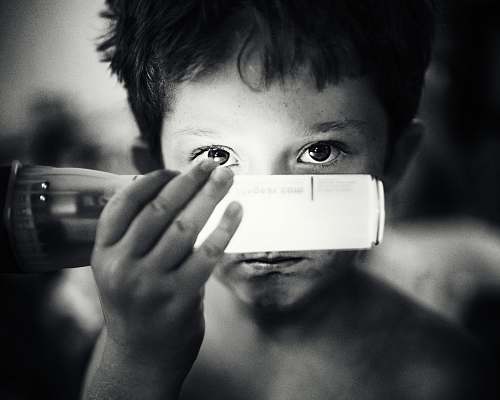 black-and-white grayscale photo of boy holding light bulb people