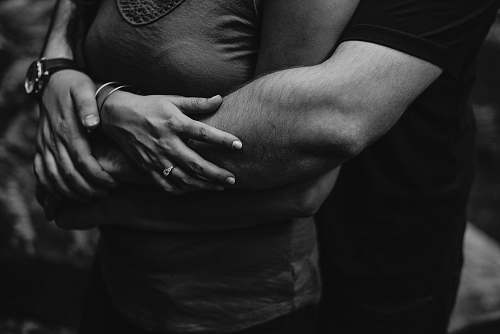 human grayscale photo of man hugging a woman black-and-white