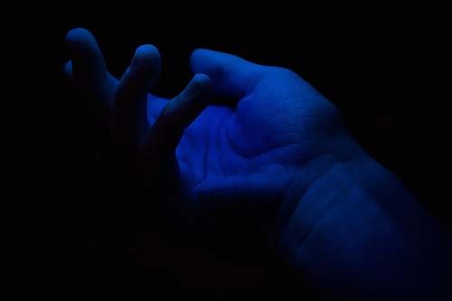 finger left person's palm somewhere in the dark
