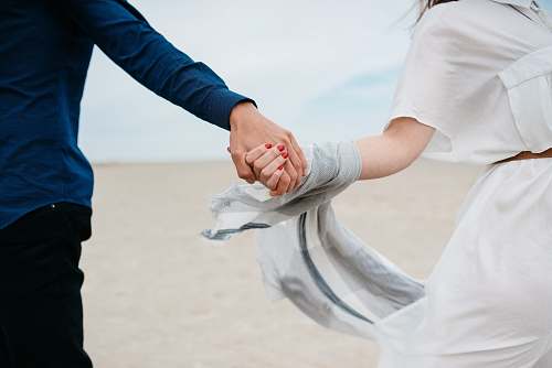 people man and woman holding hands together in field during daytime couple